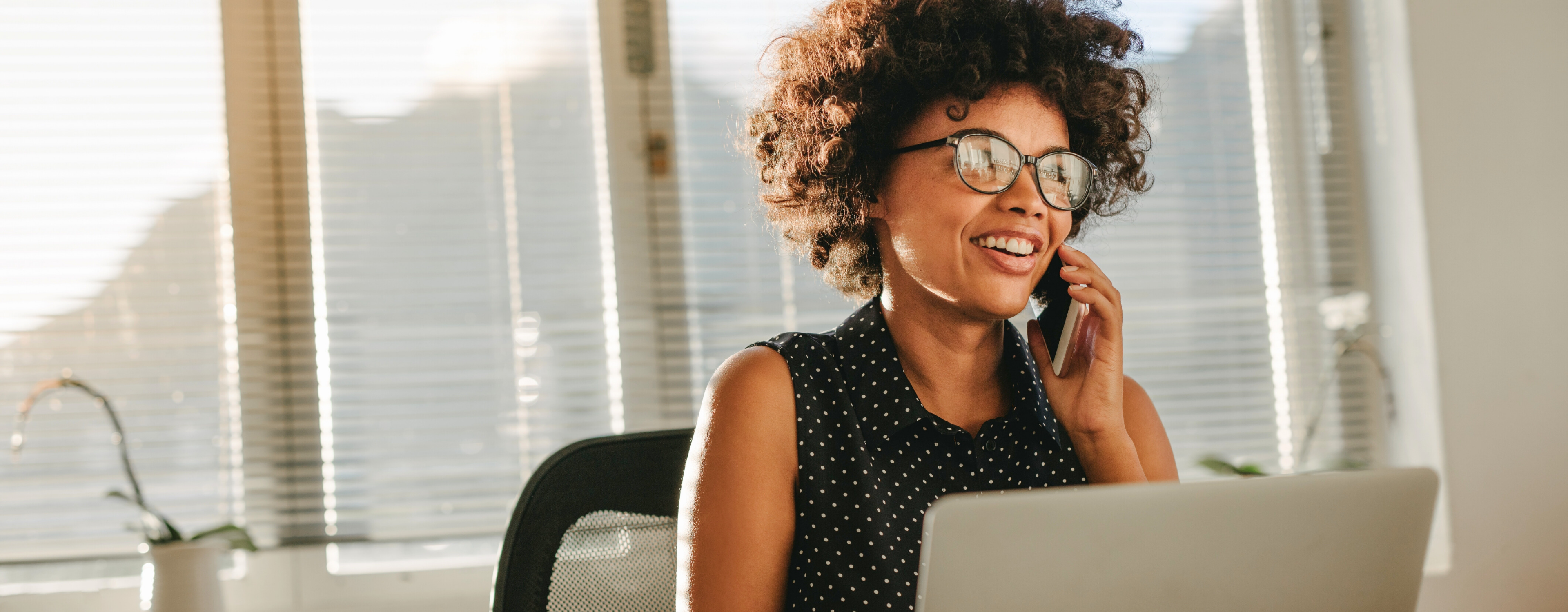 Woman on a phone call with a laptop in an office setting